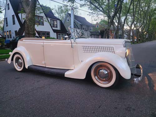 Vintage cream convertible parked on suburban street