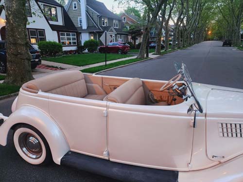Vintage cream convertible parked on suburban street