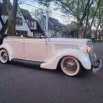 Vintage white convertible parked on suburban street
