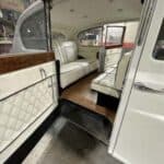 Vintage limousine interior with white leather seats and wood trim