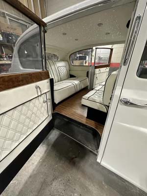 Vintage limousine interior with white leather seats and wood trim