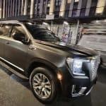 Black SUV parked on city street at night