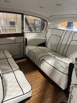 White leather seating inside classic boat cabin