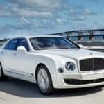 White luxury sedan driving on bridge highway