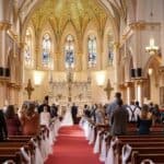 Wedding ceremony inside ornate church with guests seated