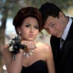 Young couple dressed formally posing at prom outdoors