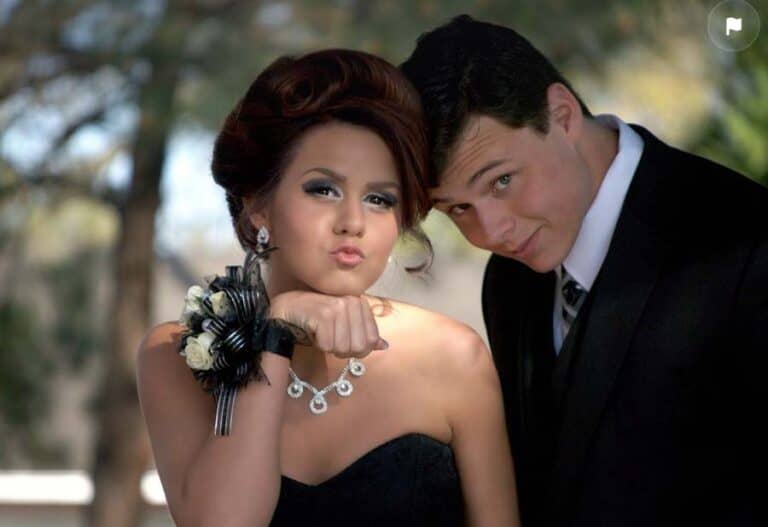Young couple dressed formally posing at prom outdoors