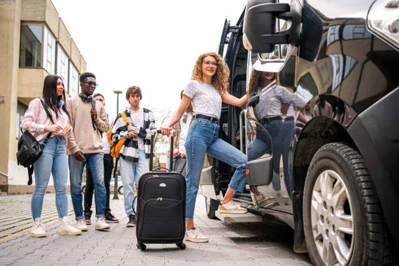 Young adults boarding van with luggage for trip