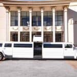 White stretch limousine parked outside grand columned building