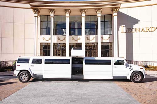 White stretch limousine parked outside grand columned building