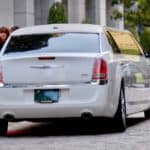 White limousine parked on red carpet outside building