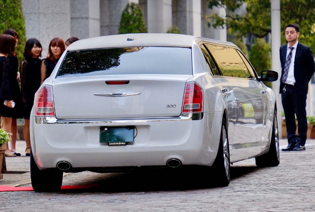 White limousine parked on red carpet outside building