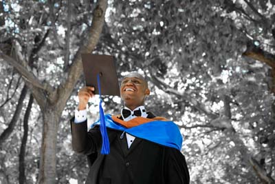 Graduate in cap and gown taking outdoor selfie