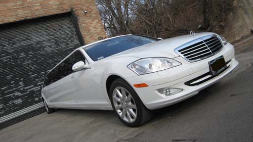 White Mercedes-Benz sedan parked near garage door