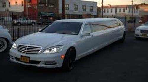 White stretch limousine parked on city street
