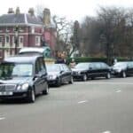 Black hearses parked along city street