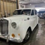 Vintage white luxury sedan parked inside garage