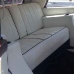 Cream leather rear bench seat in a vintage car interior