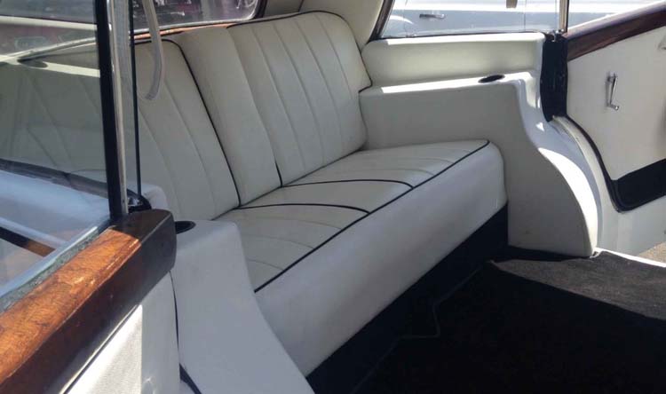 Cream leather rear bench seat in a vintage car interior