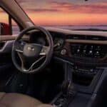 Car interior with steering wheel and sunset view