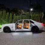 White luxury sedan with open doors at night
