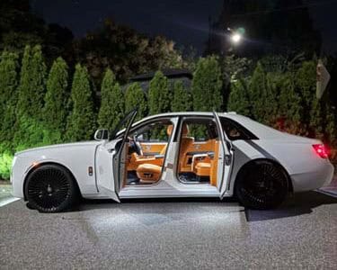 White luxury sedan with open doors at night