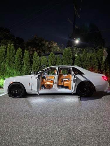 White luxury sedan with open doors at night