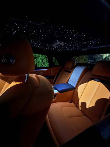 Luxury car interior with orange leather and starlit ceiling
