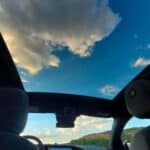 Car interior with panoramic sunroof and blue sky