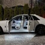 White luxury sedan with open doors at night