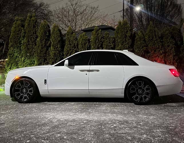 White luxury sedan parked at night
