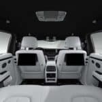 Luxury SUV interior with white leather seats and screens