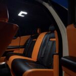 Luxury car interior with orange and black leather seats.