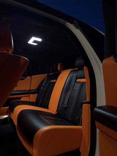 Luxury car interior with orange and black leather seats.
