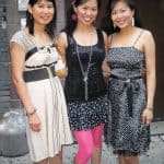 Three women posing together outdoors in dresses