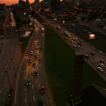 City skyline at sunset with busy highway traffic