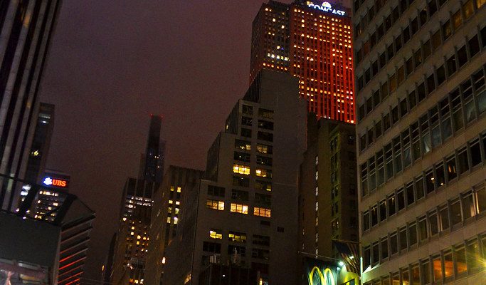 Nighttime city street with skyscrapers and neon lights