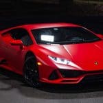 Red Lamborghini sports car with headlights on at night