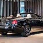 Black Rolls-Royce convertible in luxury showroom