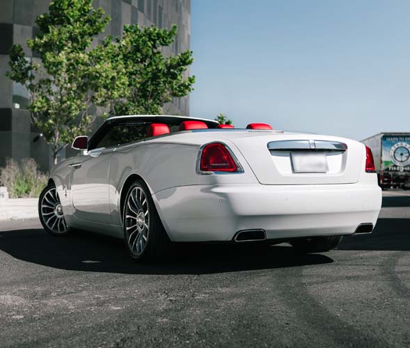 White luxury convertible with red interior parked outside