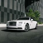 White luxury convertible parked by modern building.