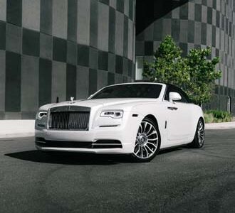 White luxury convertible parked by modern building.