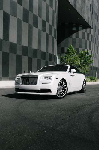White luxury convertible parked by modern building.