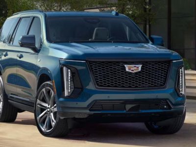 Blue Cadillac SUV parked outside modern building