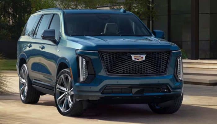 Blue Cadillac SUV parked outside modern building