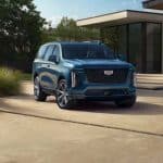 Blue Cadillac SUV parked outside modern home