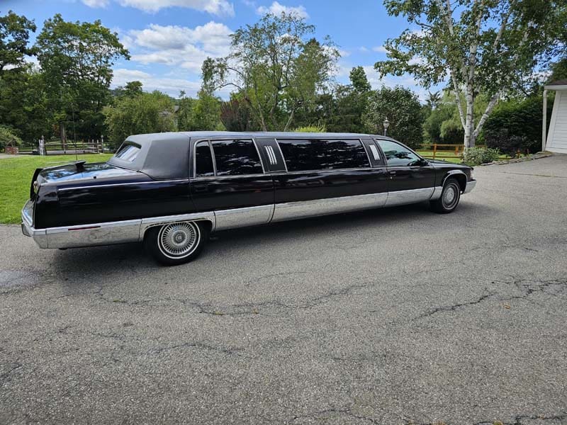 Black stretch limousine parked on residential driveway