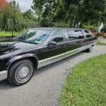 Black stretch limousine parked on residential driveway