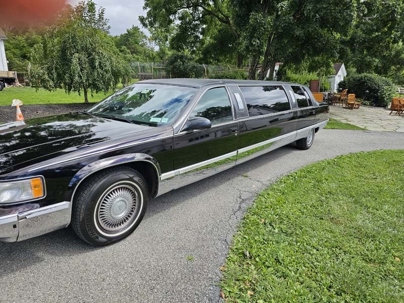Black stretch limousine parked on residential driveway