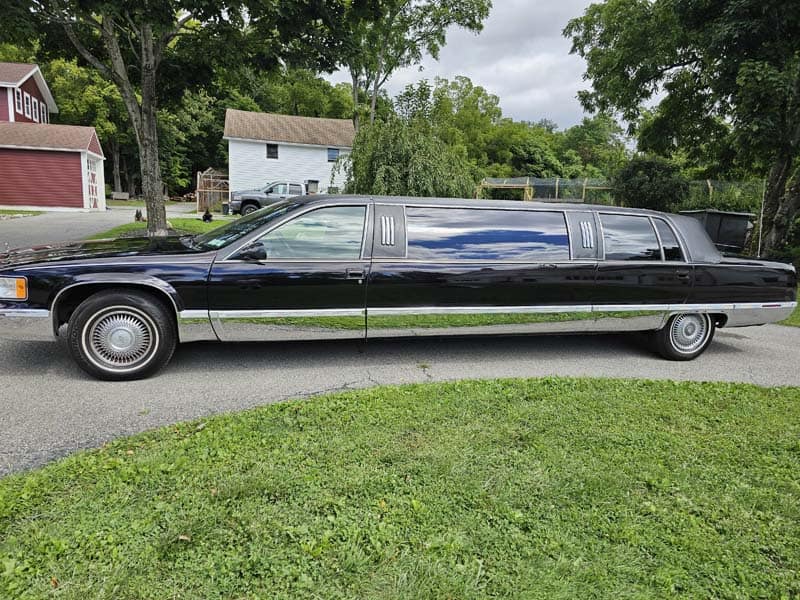 Long black stretch limousine parked on suburban street
